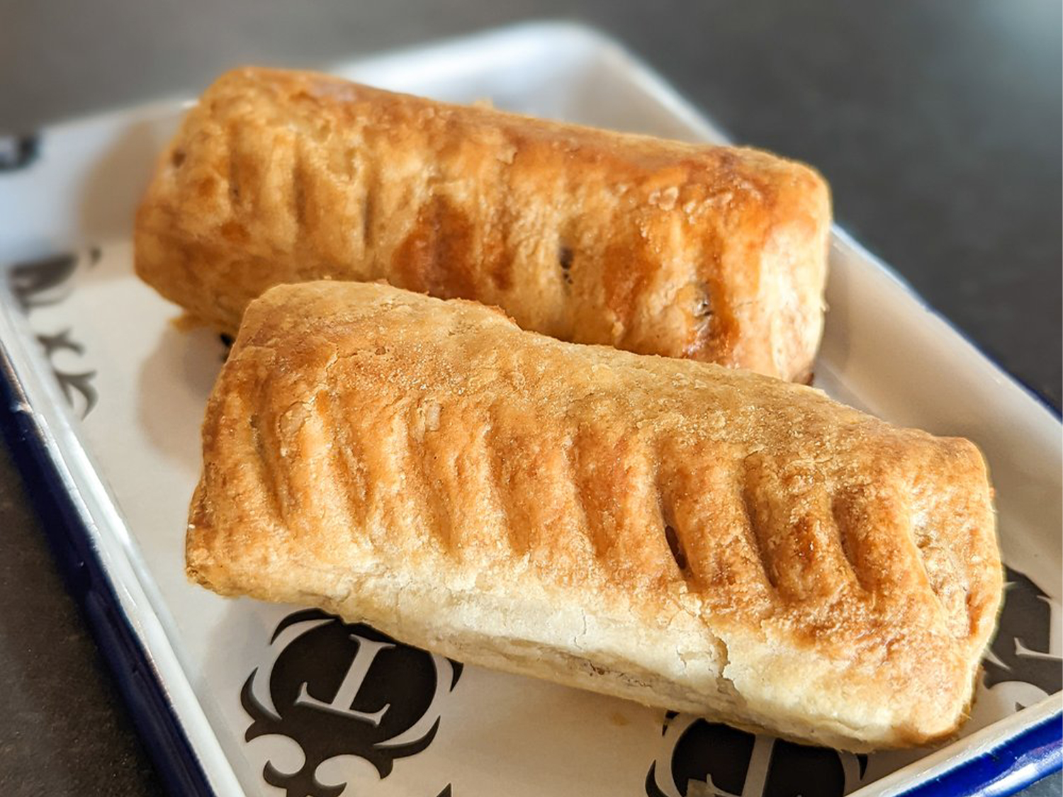 Two sausage rolls on a plate.
