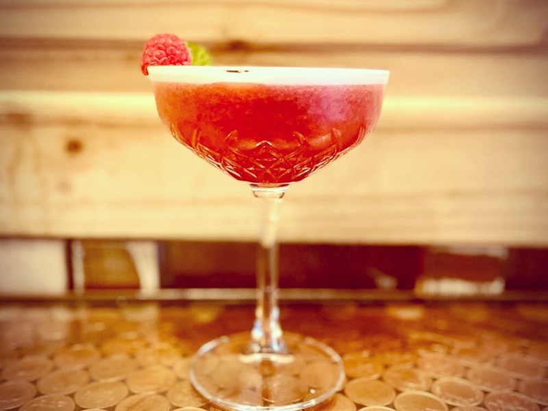 A red cocktail on a table.
