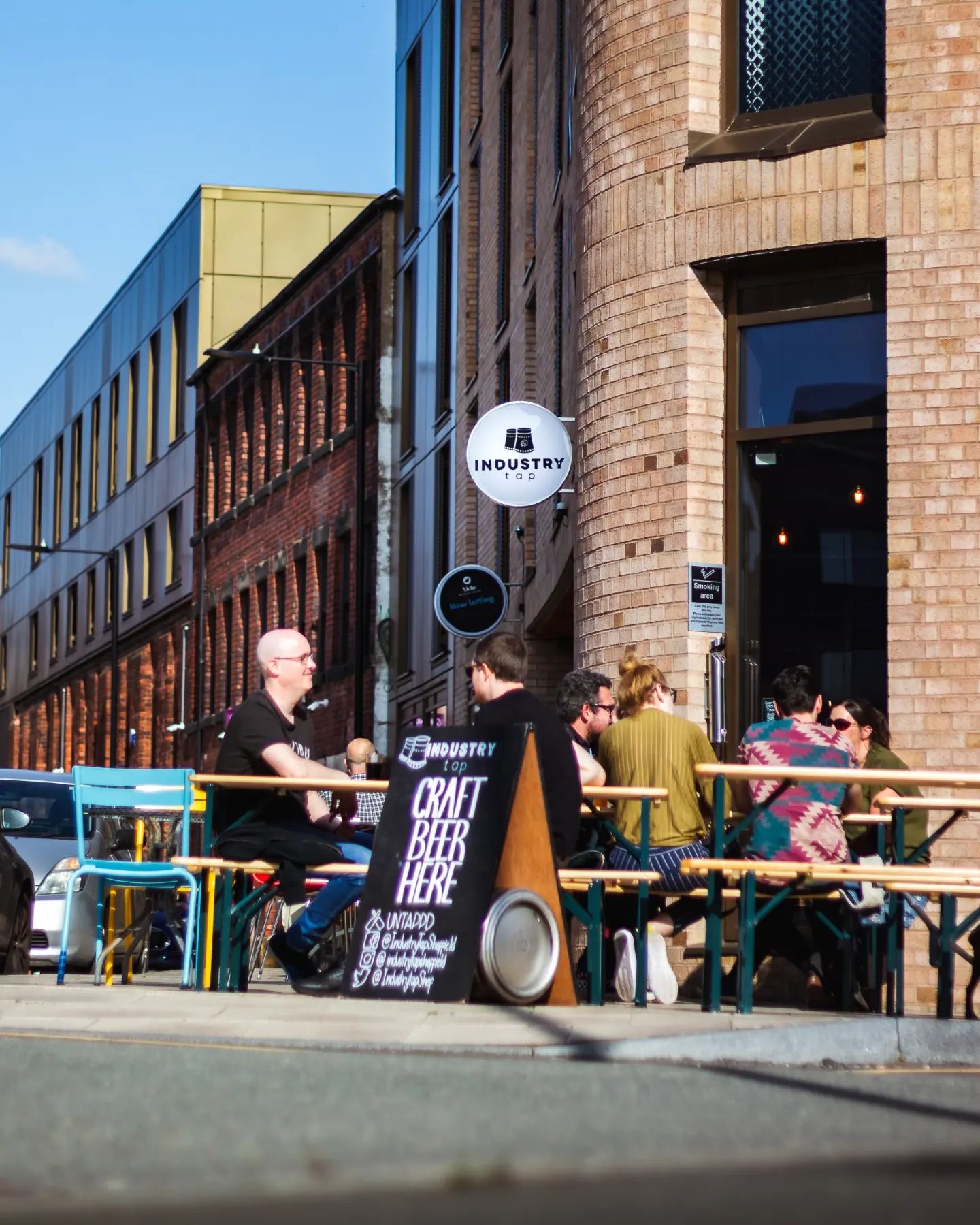 People sat at tables outside The Industry Tap.