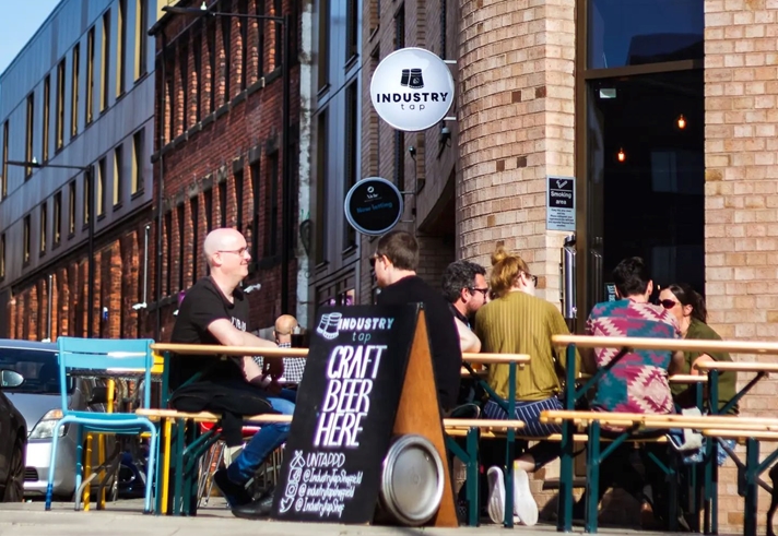 People sat at tables outside The Industry Tap.