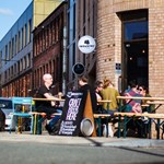 People sat at tables outside The Industry Tap.
