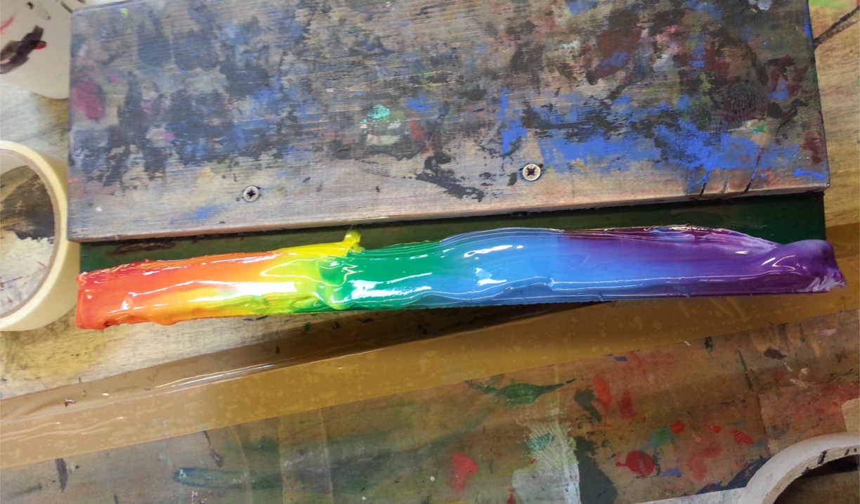 A rainbow of ink on a screen printing squeegee. 