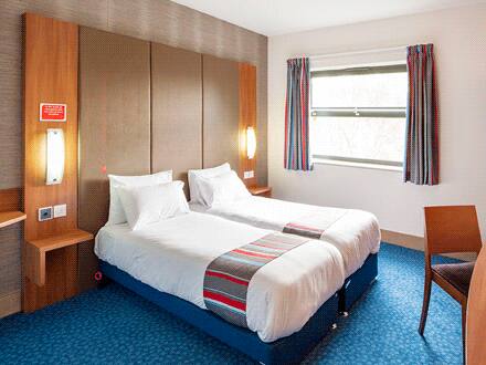 Interior of a twin room at Travelodge Sheffield Meadowhall with two single beds and modern furnishings.