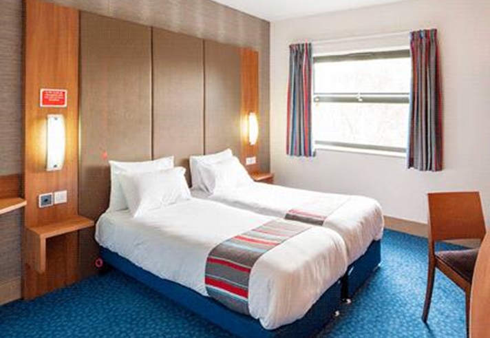 Interior of a twin room at Travelodge Sheffield Meadowhall with two single beds and modern furnishings.
