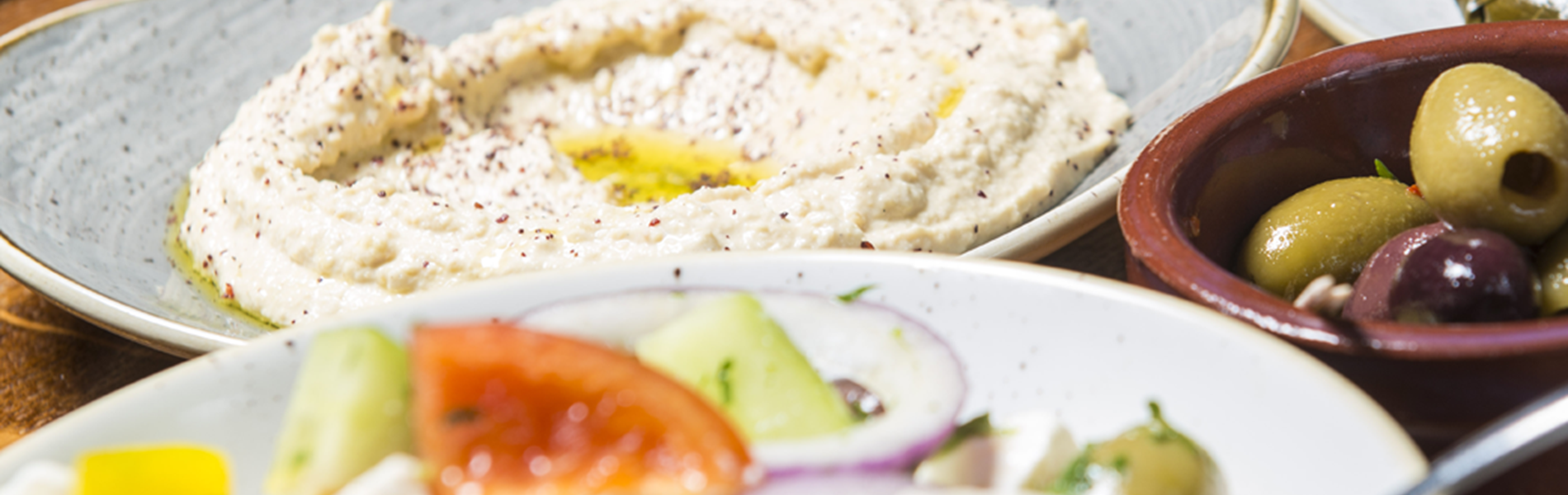 Seven plates of Turkish food laid out on a table.