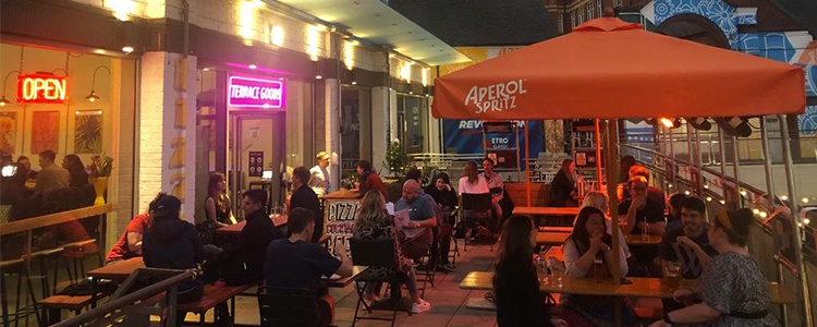 People eating outside, at night, at a cafe.