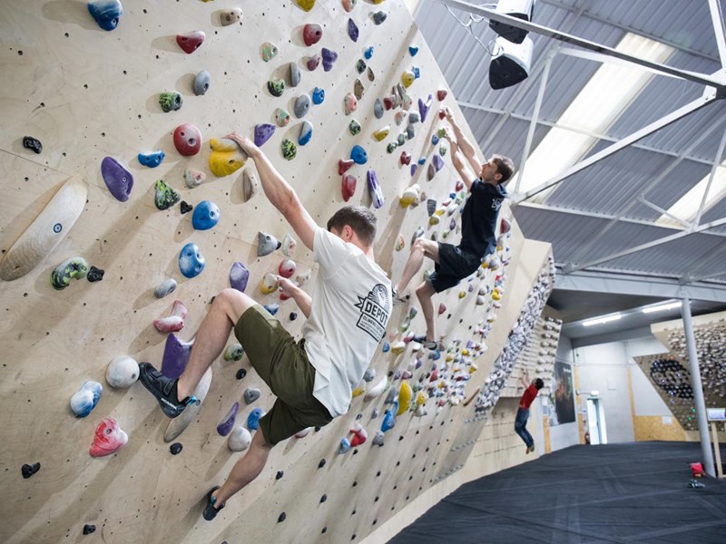 Two people on a climbing wall at Depot Climbing.