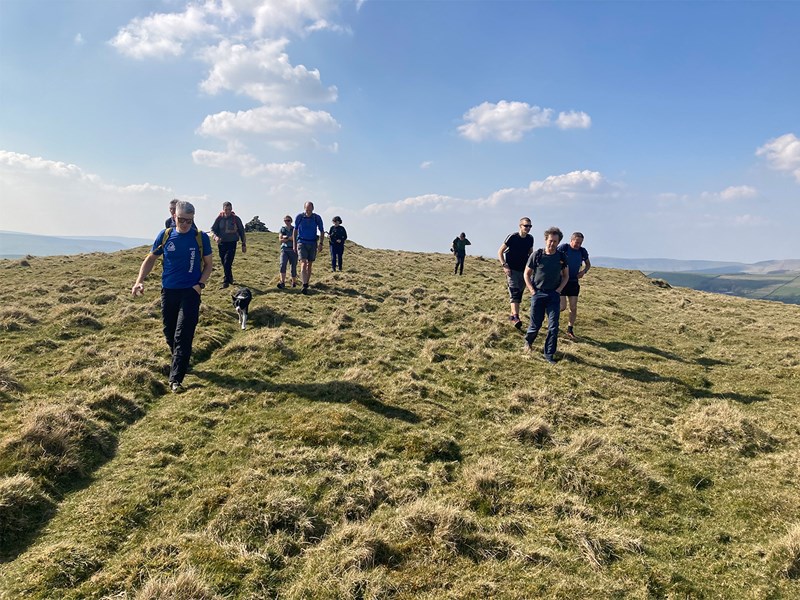 A group of people walking across open moorland.