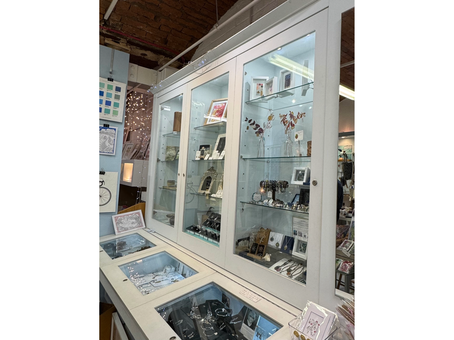 Glass display cases filled with various items for sale at All Good Stuff.