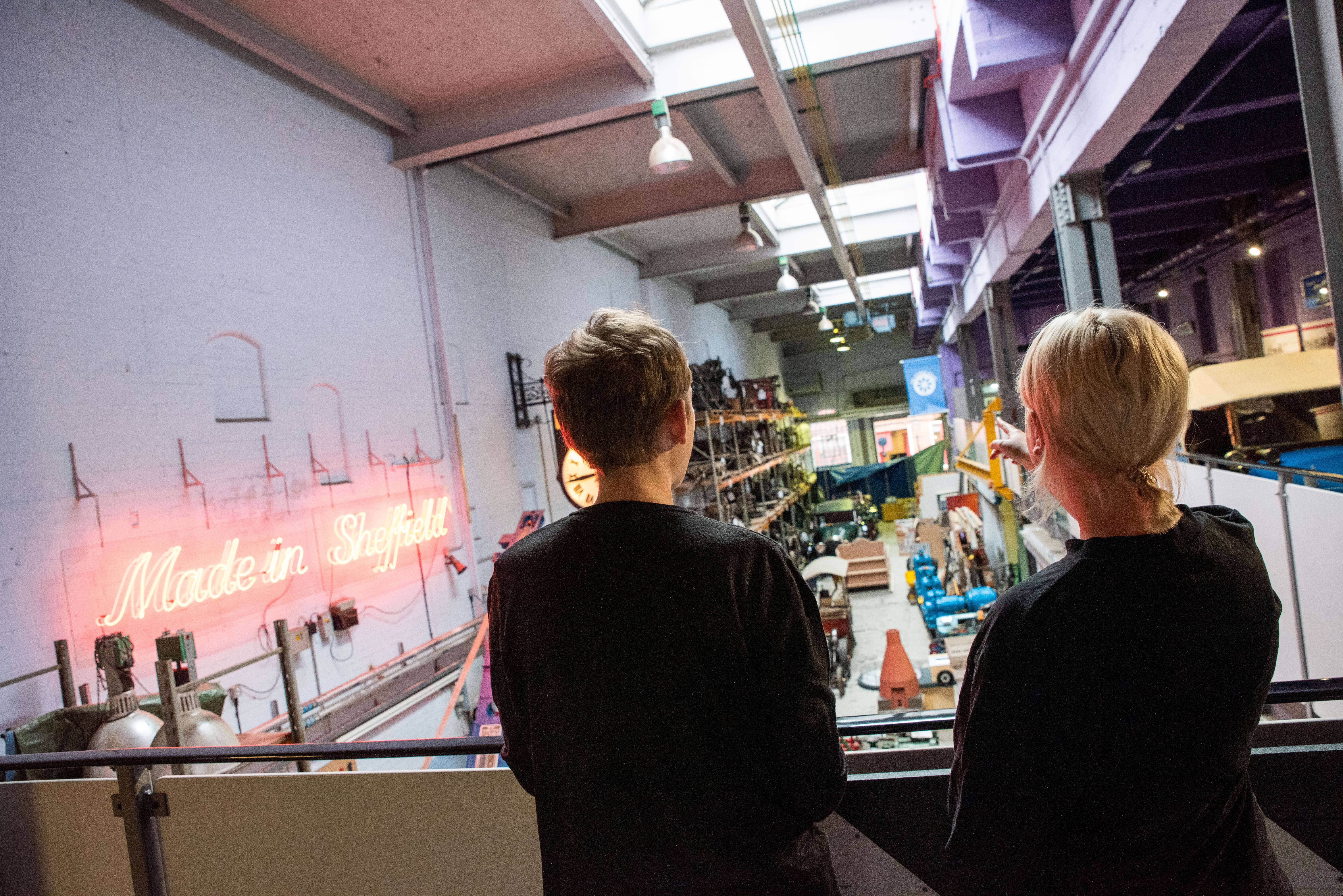 two people stood on a walkway looking down into Kelham Island Museum.