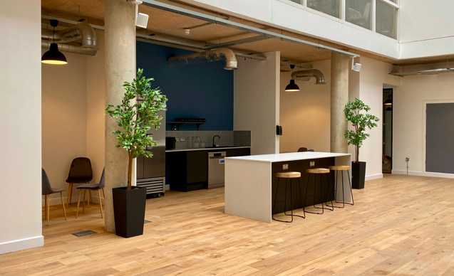 An interior shot of Cubo showing a kitchen area with free-standing worktop with three high stools.