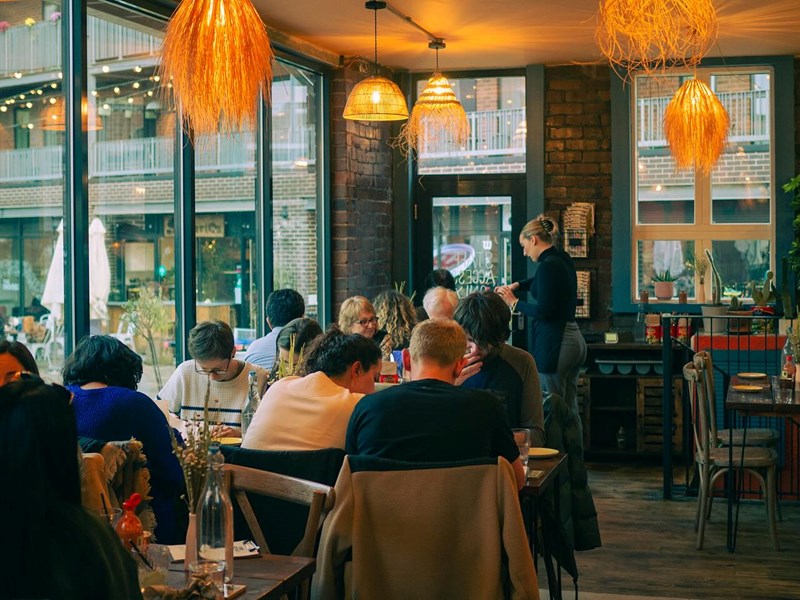 Several tables full of people enjoying their meals at Pellizco.