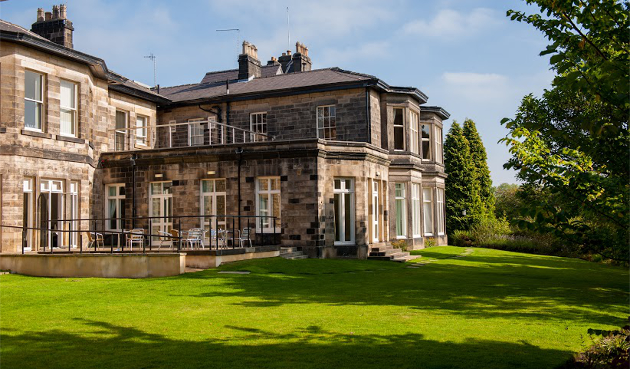 Exterior view of Halifax Hall Hotel surrounded by greenery in Sheffield.