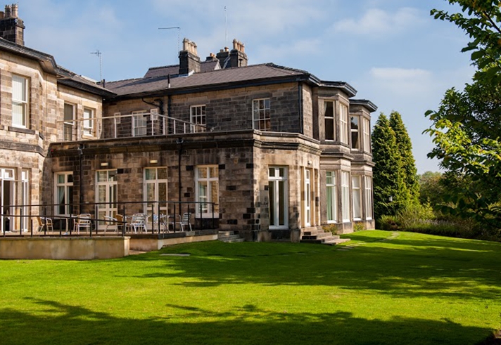 Exterior view of Halifax Hall Hotel surrounded by greenery in Sheffield.