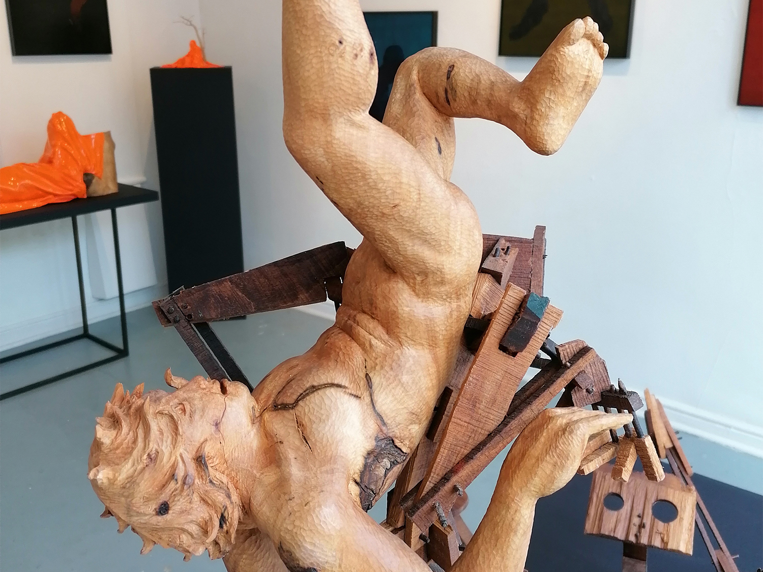 A sculpture of a human figure in wood at the Cupola Gallery.