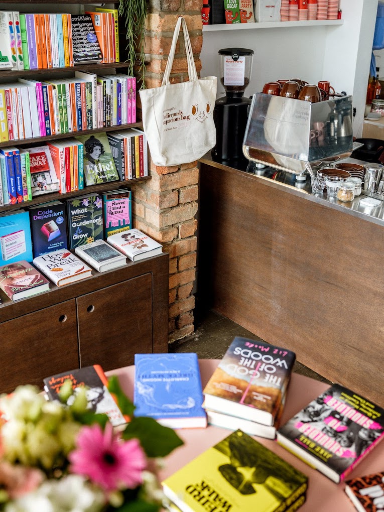 Coffee counter next to shelves of colourful books 