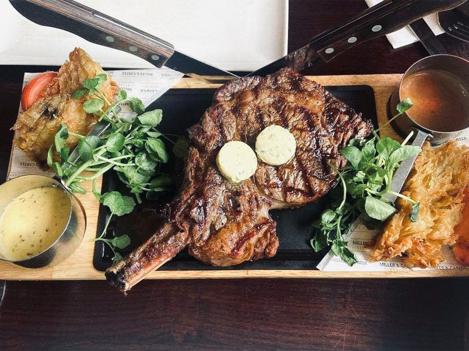 A steak on a platter with side dishes at Miller & Carter Steakhouse.