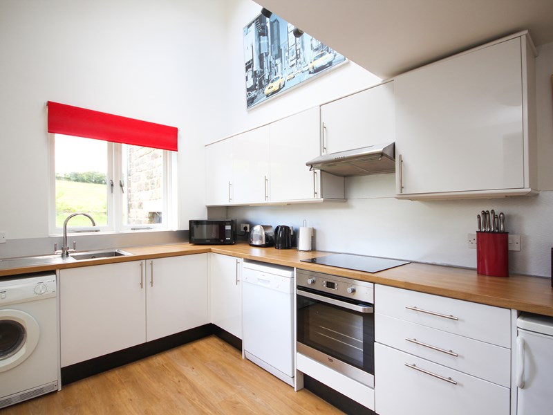 Interior view of a kitchen area with countertops, cabinets, sink, and appliances.