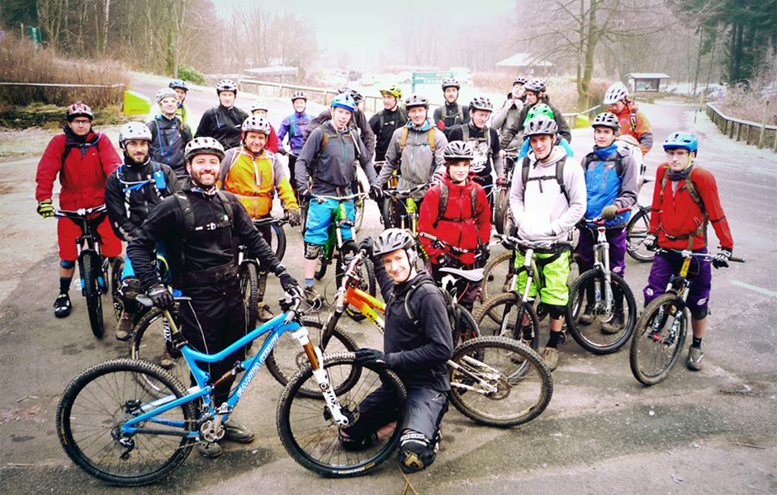 A large group of people on bikes pose for a photo.