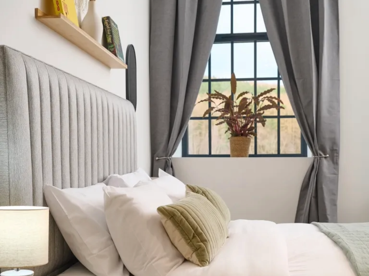 A double bed with a view out of a window at JÖRO Oughtibridge Mill.