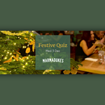 Close-up of a decorated Christmas tree with warm white lights and dried orange slices, next to a green square sign that reads “Festive Quiz, Wed 3 Dec, Marmadukes.” In the background, a wooden table is set with glassware, a gold vase, and festive decorations in a cozy indoor setting.