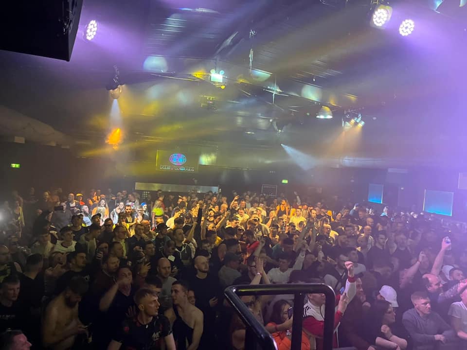 A crowd dances in a huge nightclub.