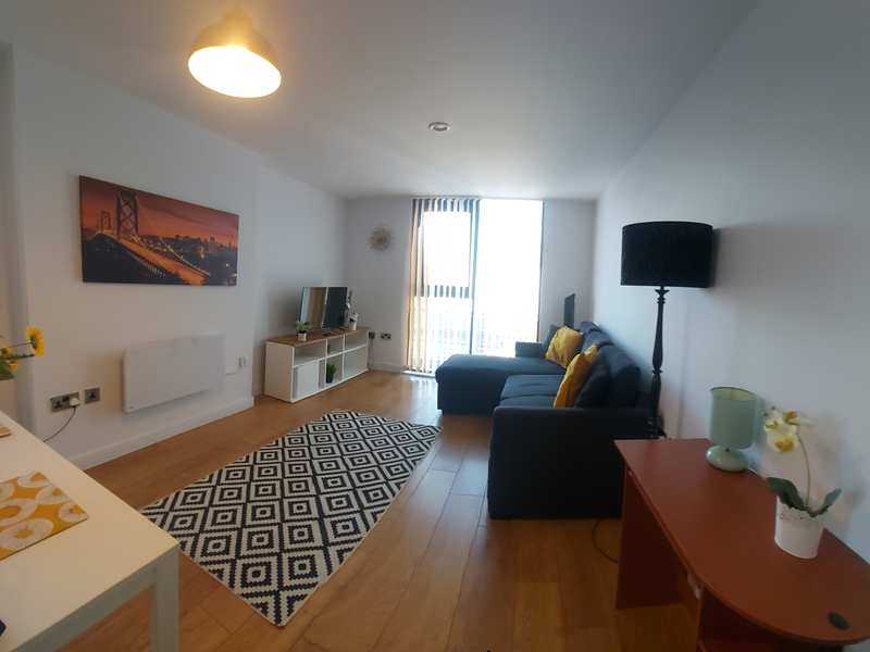 Spacious living room with a comfortable settee and a dining table with chairs.