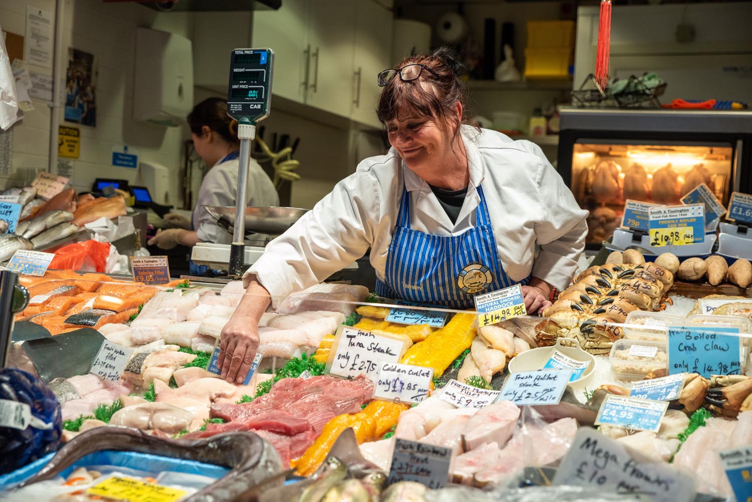 A stall holder sorting their display of fish and meat at The Moor Market.