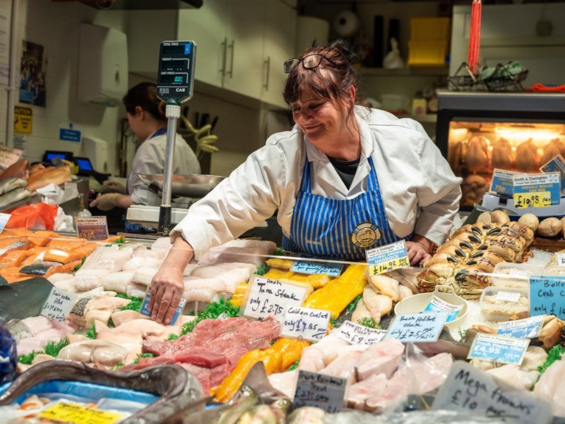 A stall holder sorting their display of fish and meat at The Moor Market.