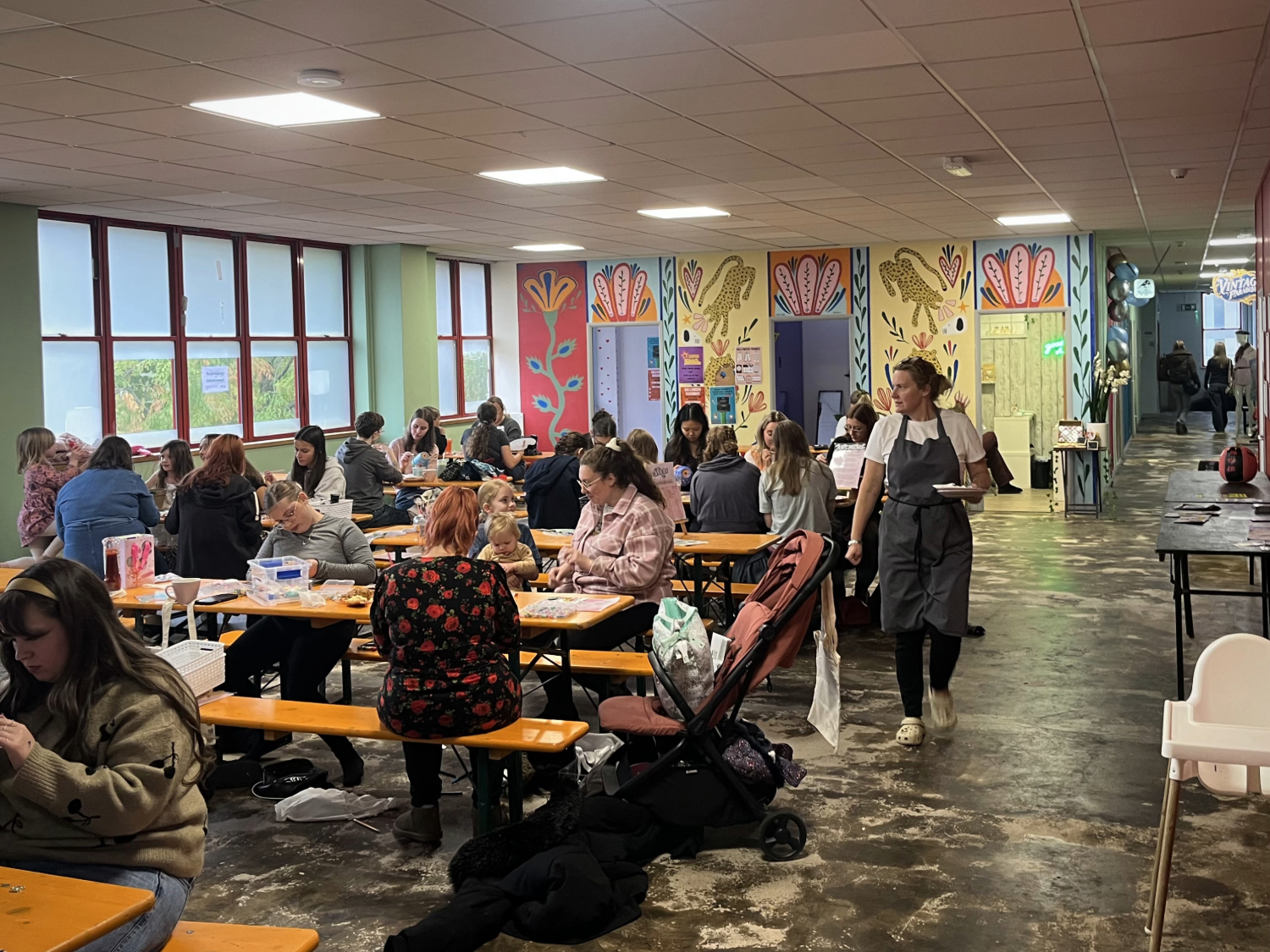 A communal area with tables and benches, full of people.