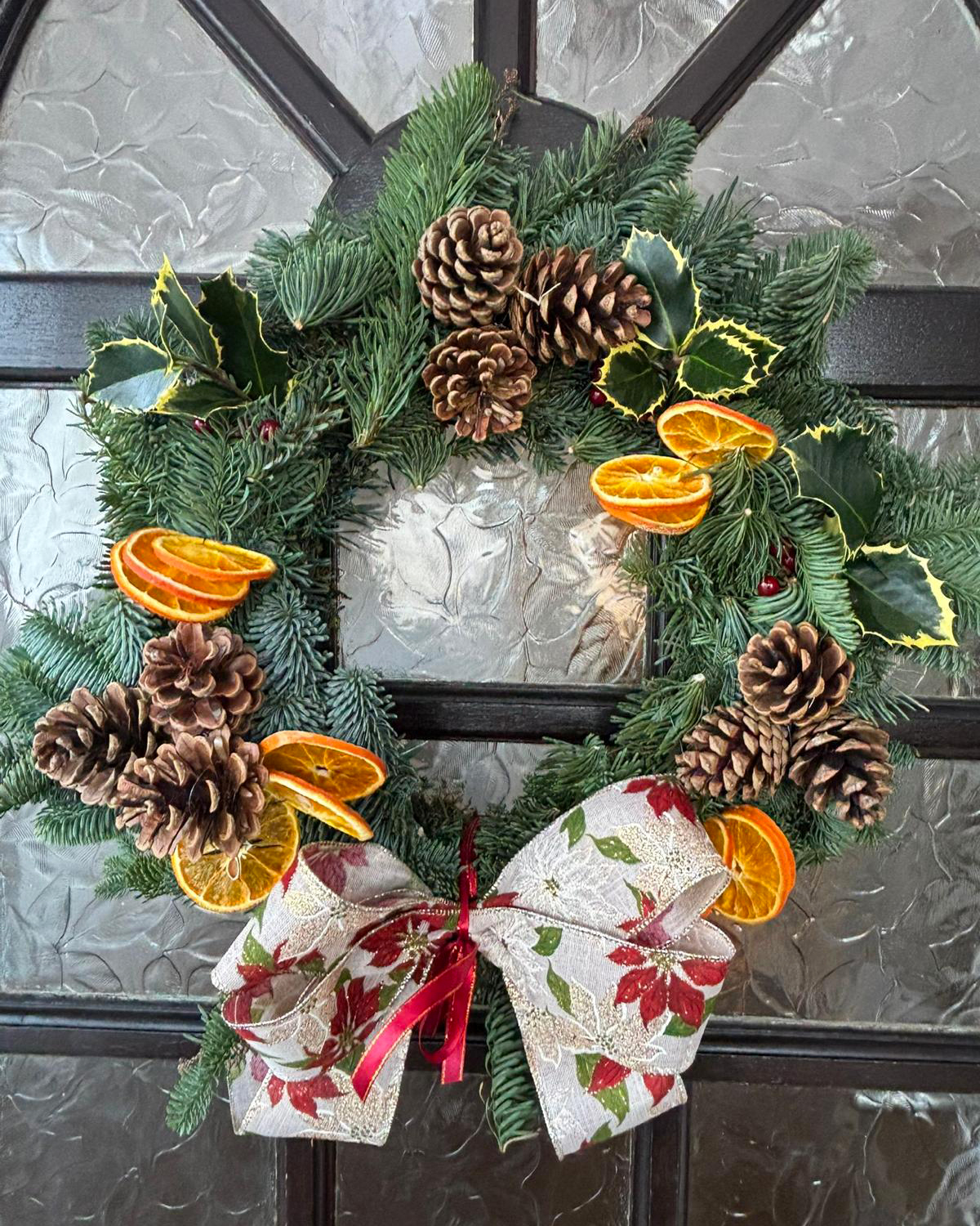 A Christmas wreath hanging on a door.