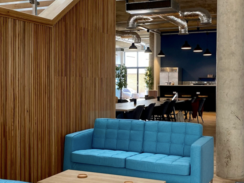 An interior shot of Cobo showing a wooden partition and a blue sofa and a low coffee table.