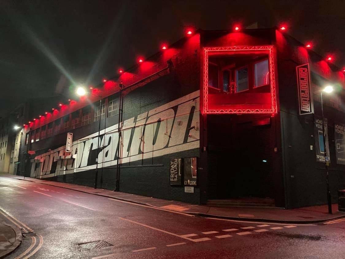 The exterior of Corporation, lit up at night.