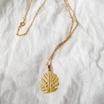 A necklace with a pendant shaped like a leaf.