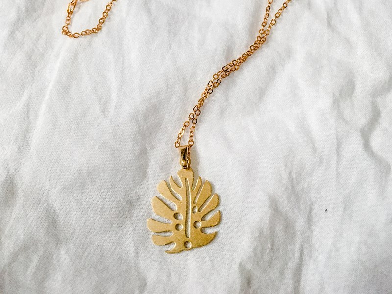 A necklace with a pendant shaped like a leaf.