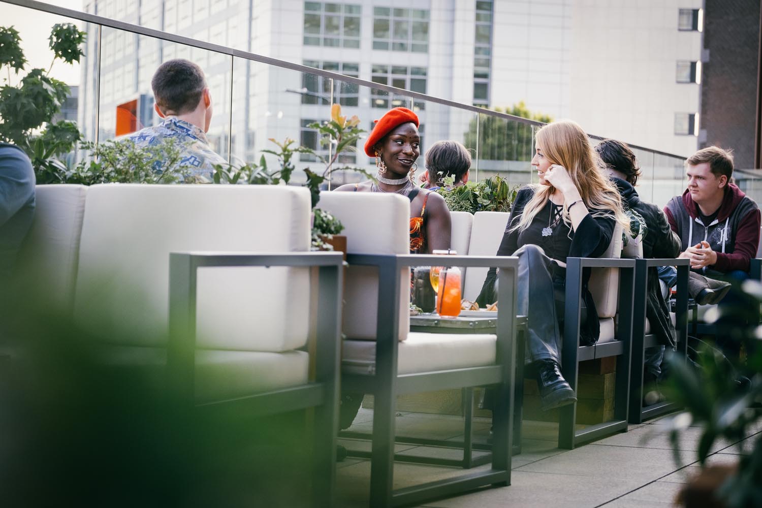 People enjoying meals in an open terrace at a restaurant.