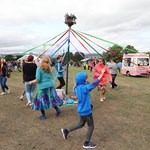 Adults and children dancing round a Maypole at the Sheffield Fayre.