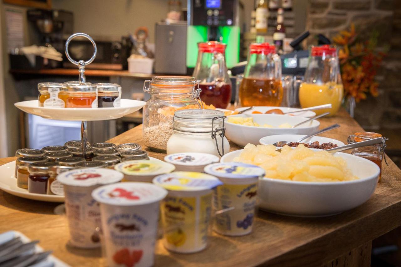 Assorted breakfast choices including cereals, fruit, pastries, and beverages arranged on a table.