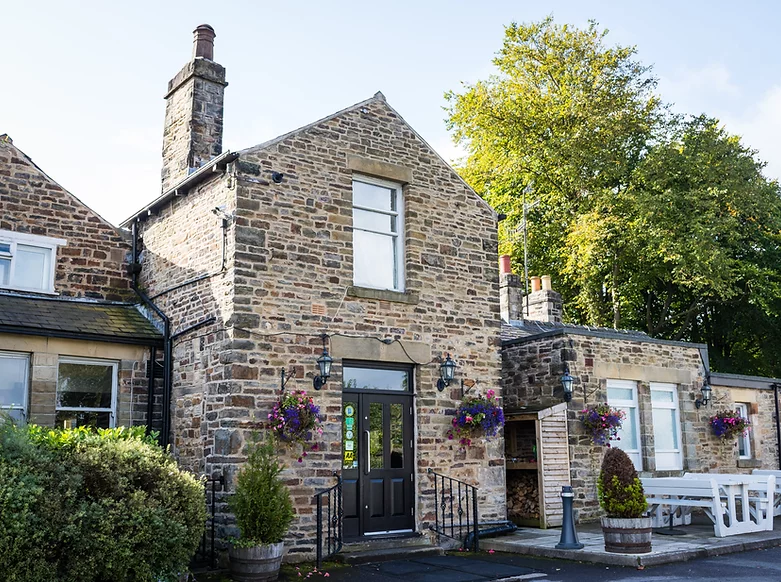 Exterior of The Cross Scythes pub showing the building and entrance.