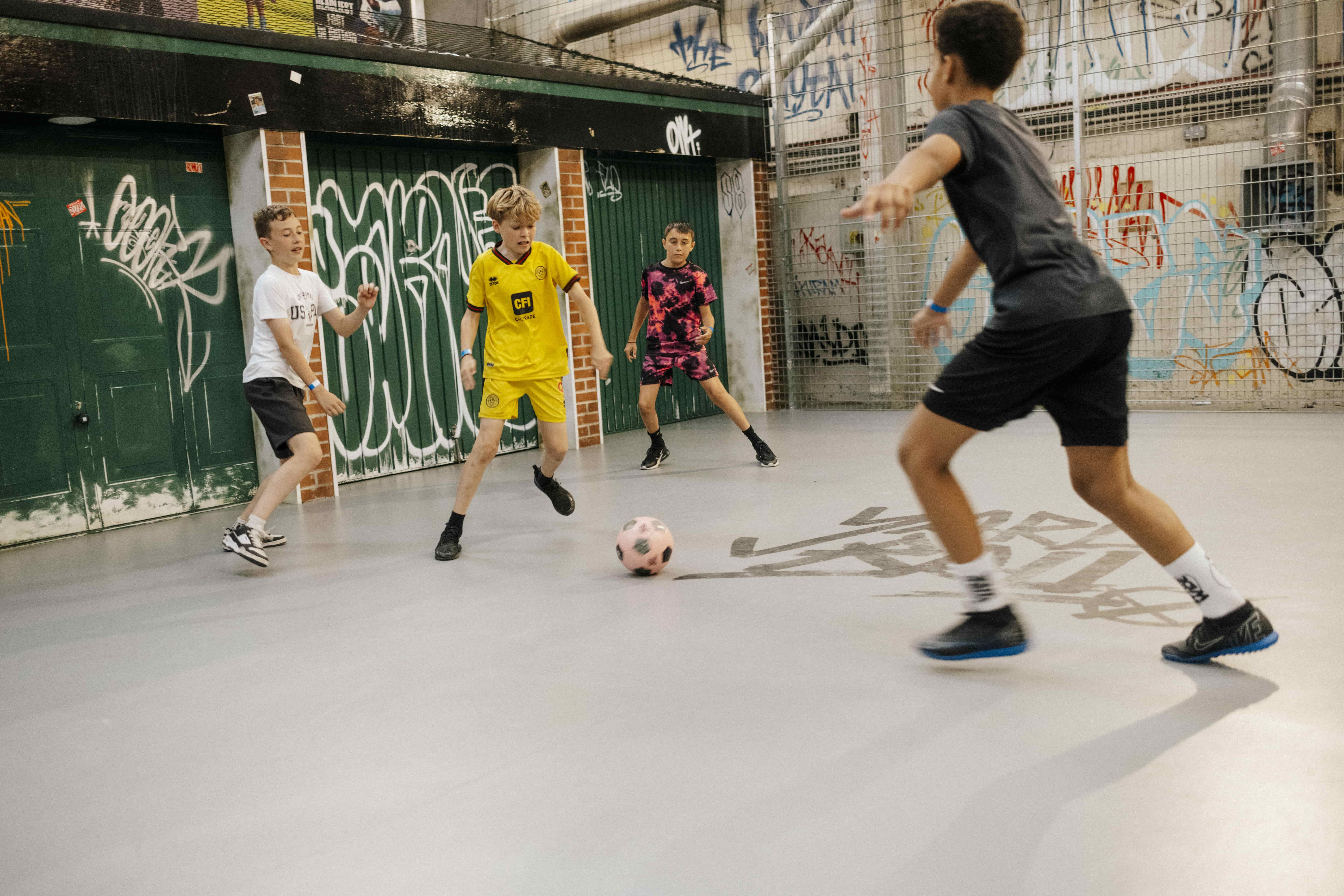 Four boys play indoor football at Yard Ball.