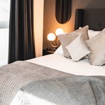 A double bed with lots od cushions.