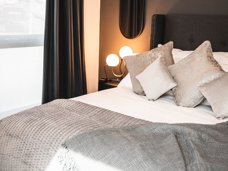 A double bed with lots od cushions.