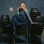 Self Esteem sitting on a big pile of stacking chairs.