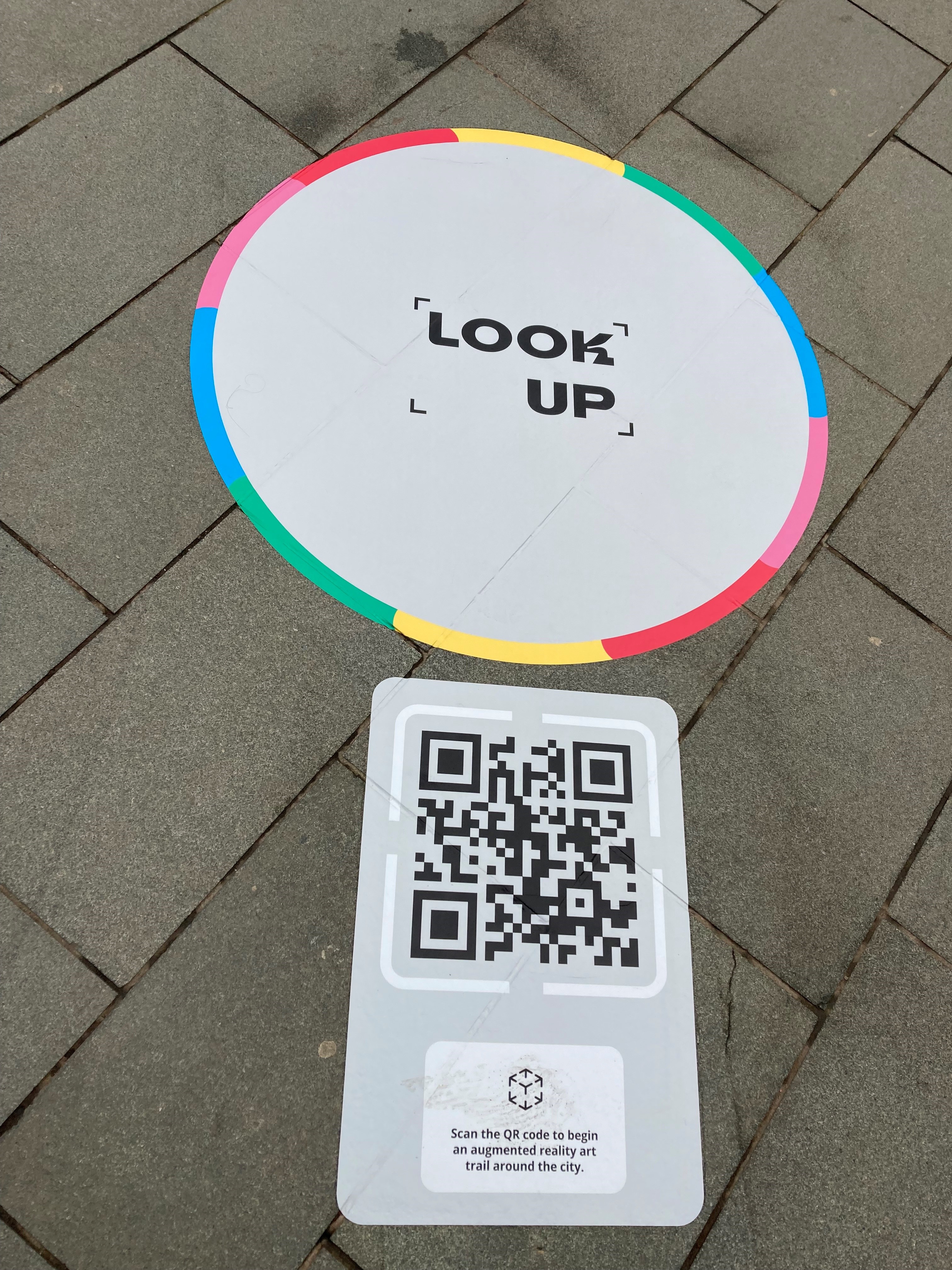 A close up of the  Look Up Portal Sticker that has been placed on paving slabs.