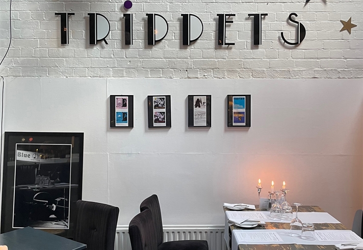 A white washed brick wall with the Trippets Lounge Bar logo on it.