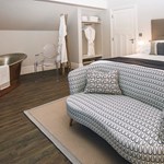 A lavish room at Brocco On The Park, with a double bed, a sofa and a free-standing copper bath.