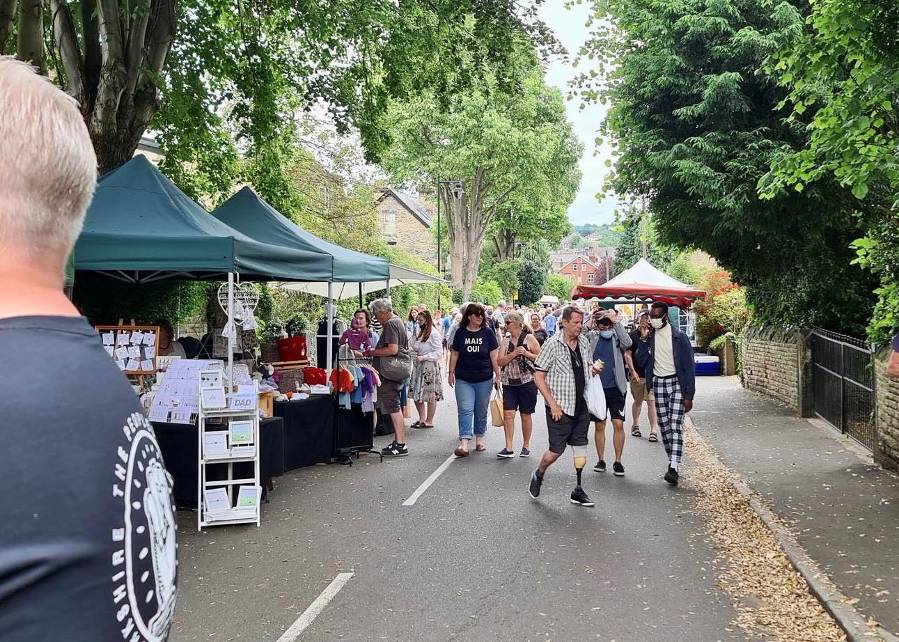 Crowds wander along stalls at the leafy Nether Edge Market 