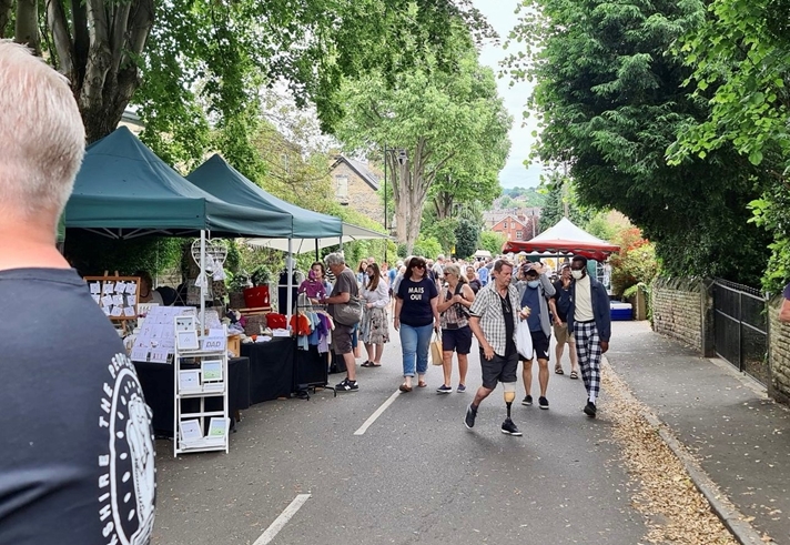 Crowds wander along stalls at the leafy Nether Edge Market