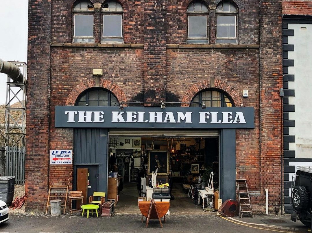 Exterior of an old red brick warehouse, over the open doors is a sign that reads 'The Kelham Flea'.
