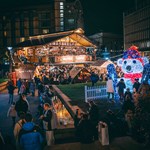 An Alpine Lodge, lit up with fairy lights, sits in the middle of the Peace Gardens as part of the Sheffield Christmas Market. In the foreground is a huge light-up polar bear.